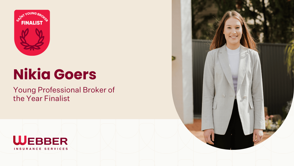 A woman with long hair stands outdoors, smiling, wearing a plaid blazer over a white shirt. The left side of the image shows text that reads, "S&N Young Broker Finalist. Nikia Goers. Young Professional Broker of the Year Finalist," with the Webber Insurance Services logo below.