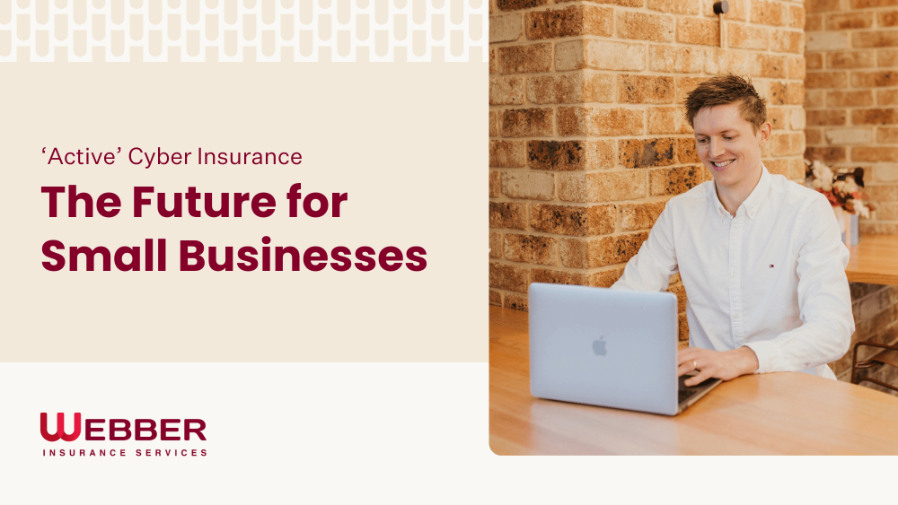 A man in a white shirt sits at a wooden table, working on a laptop in a brick-walled room. Text on the left reads, "'Active' Cyber Insurance - The Future for Small Businesses." The text at the bottom reads, "Webber Insurance Services, your partner in active cyber insurance.